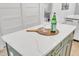 Kitchen island with quartz countertop, olive green cabinets, and a view into the rest of the kitchen at 801 N Elm St, Durham, NC 27701