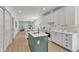 Bright kitchen features white cabinets, stainless steel appliances, a center island, and light wood floors at 801 N Elm St, Durham, NC 27701