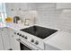 Close-up of a white stove with matching tile backsplash and quartz countertops in the newly remodeled kitchen at 801 N Elm St, Durham, NC 27701
