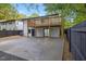 This backyard features a wooden deck, modern fence, and a large concrete patio with freshly manicured lawn at 805 Camden Ave, Durham, NC 27701
