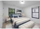 Bright bedroom features a plush bed, neutral tones, and ample natural light from dual windows at 805 Camden Ave, Durham, NC 27701