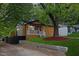 Charming home features a covered porch, wood siding, and a mature shade tree at 805 Camden Ave, Durham, NC 27701