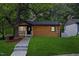 Charming home features a covered porch, wood siding, green lawn, and mature shade tree at 805 Camden Ave, Durham, NC 27701