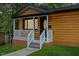 Charming cottage features a covered porch with horizontal wood siding and modern outdoor lighting at 805 Camden Ave, Durham, NC 27701