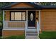 Charming cottage features a covered porch with horizontal wood siding and modern outdoor lighting at 805 Camden Ave, Durham, NC 27701