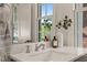 Bathroom vanity with marble countertop, elegant faucet, and decorative accents and view to the outdoors at 909 N Gregson St, Durham, NC 27701