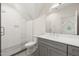 Bathroom with grey vanity, white countertop, glass enclosed shower and view to bedroom at 909 N Gregson St, Durham, NC 27701