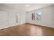 A well-lit bedroom featuring wood floors, white walls, and a view through the window at 909 N Gregson St, Durham, NC 27701