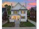 Inviting two-story home featuring a manicured lawn and a charming facade with blue shutters and stone walkway at 909 N Gregson St, Durham, NC 27701