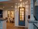 Close-up of a stylish blue front door with glass panels, a welcome mat, and white brick pillars on a cozy front porch at 909 N Gregson St, Durham, NC 27701
