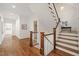 Hallway and staircase with hardwood floors, white walls, and wood accents at 909 N Gregson St, Durham, NC 27701