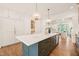 Open kitchen with a large central island, barstool seating and modern pendant lighting at 909 N Gregson St, Durham, NC 27701