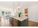 Open-concept kitchen featuring an island with counter seating, modern fixtures, and natural light at 909 N Gregson St, Durham, NC 27701