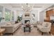 Bright living room with a marble fireplace, large windows, hardwood floors, and comfortable seating arrangement at 909 N Gregson St, Durham, NC 27701