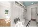 Mudroom with white cabinetry, hooks, bench, laundry, and geometric tile flooring at 909 N Gregson St, Durham, NC 27701