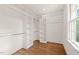 Spacious walk-in closet with built-in shelving, hanging rods and hardwood floors at 909 N Gregson St, Durham, NC 27701
