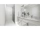 Modern bathroom with dual sinks, marble countertops, white cabinets, and a sleek glass-enclosed shower at 909 Selby Ave, Durham, NC 27713
