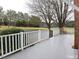 Inviting back porch with white railings and an outdoor chair overlooking the expansive backyard at 915 Phils Creek Rd, Chapel Hill, NC 27516