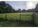 View of an expansive green backyard with fence and house in the background at 915 Phils Creek Rd, Chapel Hill, NC 27516
