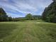Expansive backyard lawn featuring four white Adirondack chairs at 915 Phils Creek Rd, Chapel Hill, NC 27516