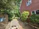 Relaxing backyard featuring a brick patio, mature trees, and outdoor seating at 915 Phils Creek Rd, Chapel Hill, NC 27516