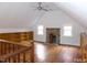 Large bonus room featuring hardwood floors, a brick fireplace, built in bookshelves and a ceiling fan at 915 Phils Creek Rd, Chapel Hill, NC 27516