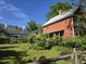 Charming home with a metal roof, manicured lawn and lots of decorative shrubbery and ornamental trees at 915 Phils Creek Rd, Chapel Hill, NC 27516