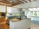 Bright kitchen features stainless steel appliances, center island, wood floors and view to fireplace at 915 Phils Creek Rd, Chapel Hill, NC 27516