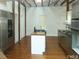 Bright kitchen features stainless steel appliances, center island, wood floors and wooden support beams at 915 Phils Creek Rd, Chapel Hill, NC 27516