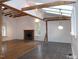 Bright living room boasting a fireplace, wooden beams, skylights, and a mix of hardwood and tile floors at 915 Phils Creek Rd, Chapel Hill, NC 27516