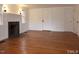 Bright living room with fireplace, wood floors, white walls, and windows with natural light at 915 Phils Creek Rd, Chapel Hill, NC 27516