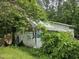 Exterior view of weathered outbuilding surrounded by overgrown vegetation at 915 Phils Creek Rd, Chapel Hill, NC 27516