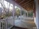 Expansive porch with white railings, offering a tranquil outdoor space with views of surrounding trees at 915 Phils Creek Rd, Chapel Hill, NC 27516