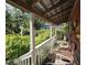 Inviting porch with white railings, wood chairs, and lush greenery, offering a tranquil outdoor space at 915 Phils Creek Rd, Chapel Hill, NC 27516
