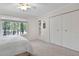 Bright bedroom featuring a large window with views, ceiling fan, and ample closet space, offering comfort and storage at 102 Rosebrooks Dr, Cary, NC 27513