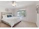 Serene bedroom with a large window, ceiling fan, comfortable bed, and neutral tones for a relaxing ambiance at 102 Rosebrooks Dr, Cary, NC 27513