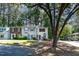 Exterior view of townhomes with well-manicured lawns, mature trees, and ample parking at 102 Rosebrooks Dr, Cary, NC 27513