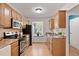 Well-lit kitchen with stainless steel appliances, light wood cabinets and flooring, and a pleasant window view at 102 Rosebrooks Dr, Cary, NC 27513