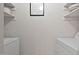 Spacious laundry area with side-by-side washer and dryer units and ample storage space on shelving at 102 Rosebrooks Dr, Cary, NC 27513