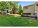 Lush backyard offers a private outdoor retreat, complete with a pergola, mature trees, and verdant landscaping at 104 Crossway Ln, Holly Springs, NC 27540
