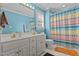 Bathroom featuring a dual sink vanity, toilet, and a bathtub with colorful shower curtain at 104 Crossway Ln, Holly Springs, NC 27540