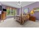 Bedroom with four-poster bed with elaborate bedspread and large windows at 104 Crossway Ln, Holly Springs, NC 27540