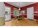 Cozy dining area with red walls, a window overlooking the backyard, and an adjacent sunroom at 104 Crossway Ln, Holly Springs, NC 27540
