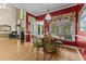 Elegant dining room with a view to the sunroom and fireplace, accented by stylish red walls at 104 Crossway Ln, Holly Springs, NC 27540