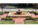 Outdoor water fountain feature surrounded by brick, stone, and manicured landscaping at 104 Crossway Ln, Holly Springs, NC 27540