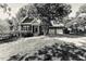 Charming brick home with a well-manicured lawn, mature trees, and two-car garage at 104 Crossway Ln, Holly Springs, NC 27540