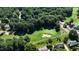 Aerial view of a lush green golf course with mature trees, sand traps and manicured greens at 104 Crossway Ln, Holly Springs, NC 27540