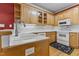 Well-lit kitchen featuring wooden cabinets, white appliances, and an efficient layout at 104 Crossway Ln, Holly Springs, NC 27540