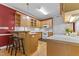 Functional kitchen featuring wooden cabinets, white appliances, and an eat-in bar area at 104 Crossway Ln, Holly Springs, NC 27540