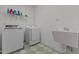Laundry room with a utility sink, washer, dryer, and overhead storage, perfect for organizing cleaning supplies at 104 Crossway Ln, Holly Springs, NC 27540